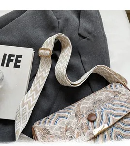 Close-up of stylish broad strap with geometric patterns and wave embroidery on crossbody bag