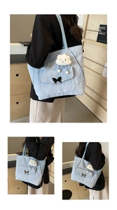 Light blue nylon tote bag with bow detail and cloud plush charm shown on a model