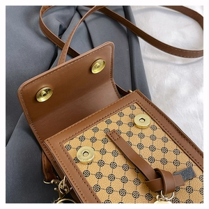 Détail d'un petit sac bandoulière en similicuir marron avec motifs de trèfles