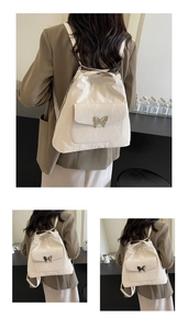 Detail of off-white backpack with crinkled texture and silver butterfly buckle