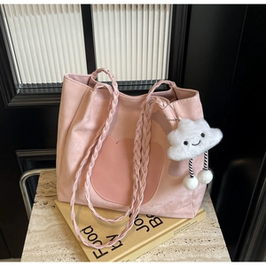 Vue détaillée du sac cabas rose avec silhouette de chat et breloque nuage en peluche sur pierre