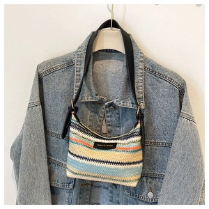 Close-up of rainbow woven shoulder bag with FASHION BAGS leather label and striped pattern