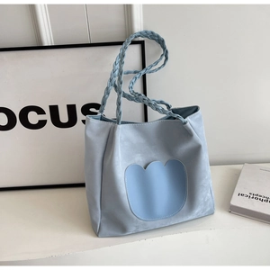 Vue détaillée du sac cabas bleu clair avec poignée tressée et applique de tulipe