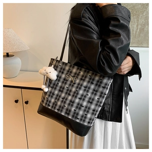 Detail of checkered tote bag with metal bow accent and white cloud plush charm