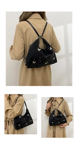 Detail of black pleated tote bag with silver butterfly charms and versatile straps