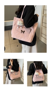Detail of pink pleated tote bag featuring silver butterfly buckle and cloud plush charm
