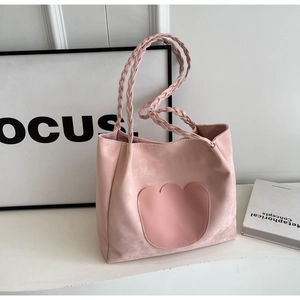 Détail du sac cabas en daim rose avec poche pétale de tulipe et bandoulière tressée