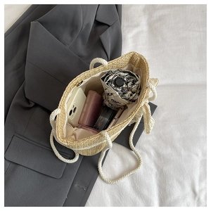 Spacious interior of straw tote bag showing umbrella and phone storage capacity
