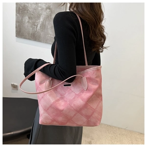 Detailansicht der rosa gesteppten Shopper-Tasche mit Silberplakette an einem Model