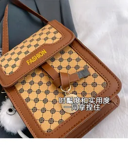 Détail du sac à bandoulière marron avec motif trèfle et breloque en peluche