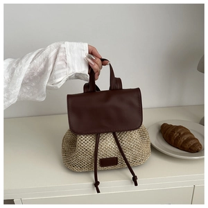 Detailed view of women's mini straw backpack with dark brown leather straps and flap