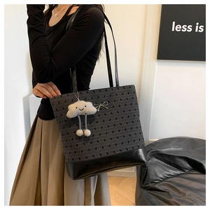 Detail of grey patterned tote with black leather base and cute cloud plush charm