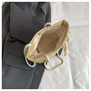Detail view of woven straw tote bag with white cotton rope handles and large capacity