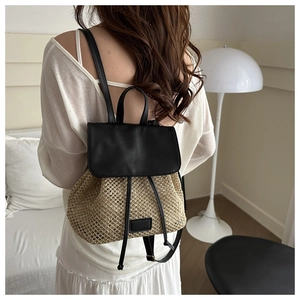 Detail view of woven straw backpack with black leather flap on model back