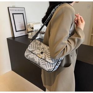 Detail of canvas small square bag with monochrome wave pattern and wide geometric strap