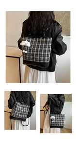 Detail of checkered tote bag with plush cloud charm and metallic bow ornament