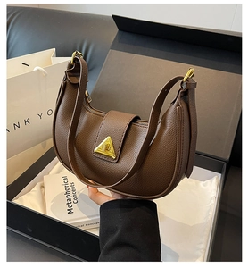 Détail du sac en cuir litchi marron foncé avec élégant fermoir rotatif triangulaire doré