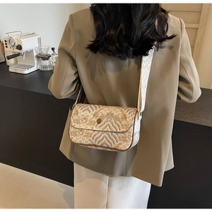 Detail of vintage crossbody bag with cloud pattern and wide geometric woven strap