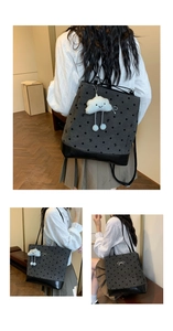 Detail of grey polka dot canvas tote bag with black leather base and plush cloud charm