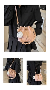 Detailed views of a pink suede bucket bag with woven handle and plush charm detail