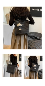Detail of grey jacquard tote bag with silver bow and plush cloud charm on leather base