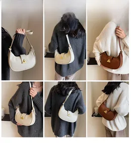 Vue détaillée du sac à bandoulière en demi-lune avec boucle en métal triangulaire dorée
