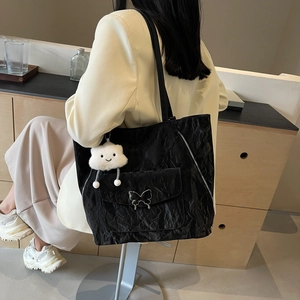 Large black textured nylon tote bag with silver butterfly buckle and cloud charm accessory