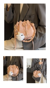 Dettaglio borsa a secchiello rosa con manico intrecciato e ciondolo mostro peluche