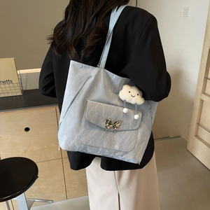 Light blue large capacity tote bag with butterfly buckle and cloud charm on model