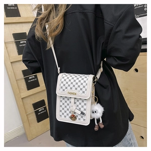 Vue détaillée du mini sac bandoulière blanc avec monogramme gris et pendentif en peluche