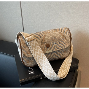 Detail of traditional jacquard fabric with cloud patterns and brown leather trim on bag