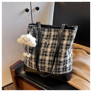 Detailed shot of checkered tote bag with bow patterns and plush cloud keychain charm
