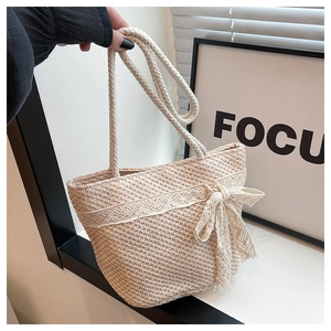Close-up of woven straw bag detail featuring delicate lace trim and sweet bow decoration