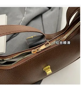 Détails du zip doré fluide et du cuir grainé sur un sac à bandoulière marron vintage