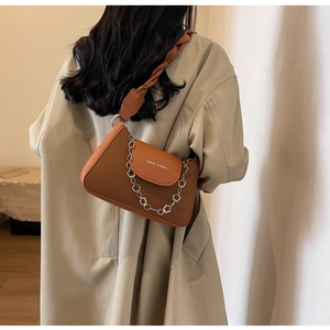 Detail of vintage brown shoulder bag with silver flower chain and branded logo flap