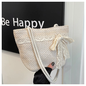 Detail of a straw tote bag with elegant white lace borders and large side bow accents