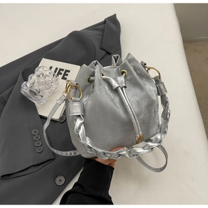 Detail of silver drawstring bucket bag with woven handle and metallic silk finish