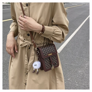 Détail du sac à bandoulière rétro monogrammé avec charm monstre et texte de mode