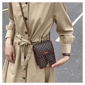 Gros plan d'un sac à bandoulière vintage en cuir marron avec motif de treillis rétro