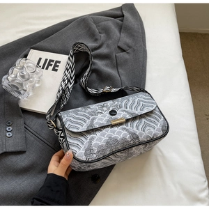 Macro detail of black and white wave pattern crossbody bag with wide jacquard strap