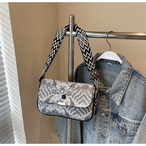 Detail of jacquard small square bag with wave pattern and geometric wide strap