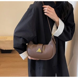 Détail du sac bandoulière en cuir litchi marron avec boucle triangulaire dorée