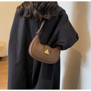 Gros plan détaillé du sac hobo en cuir marron avec boucle métallique dorée élégante