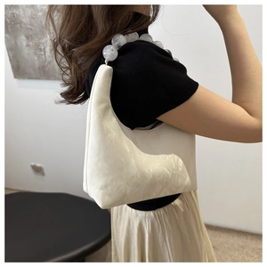 Close-up of off-white hobo bag with distinctive marble-textured large bead handle strap