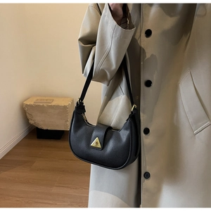 Détail du sac à bandoulière demi-lune en cuir noir grainé avec boucle dorée chic