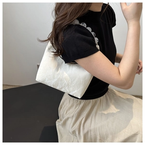 Close-up of white marble pattern shoulder bag with decorative clear beaded chain strap