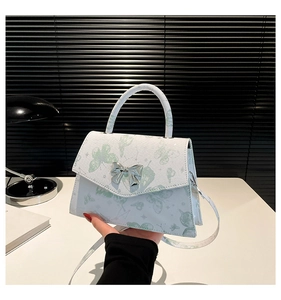 Détail du sac bandoulière en PU blanc avec imprimé papillon vert et fermoir nœud