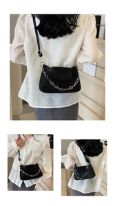 Detail showing the adjustable strap and silver flower chain on black suede crossbody bag
