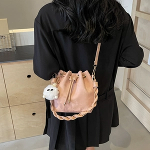 Pink drawstring bucket bag with woven handle and plush monster charm for women