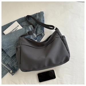Close-up of dark grey large capacity tote bag with adjustable strap and drawstring detail